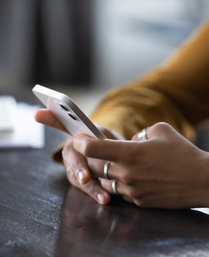 Subtema Internet e comunicações: mãos com telemóvel